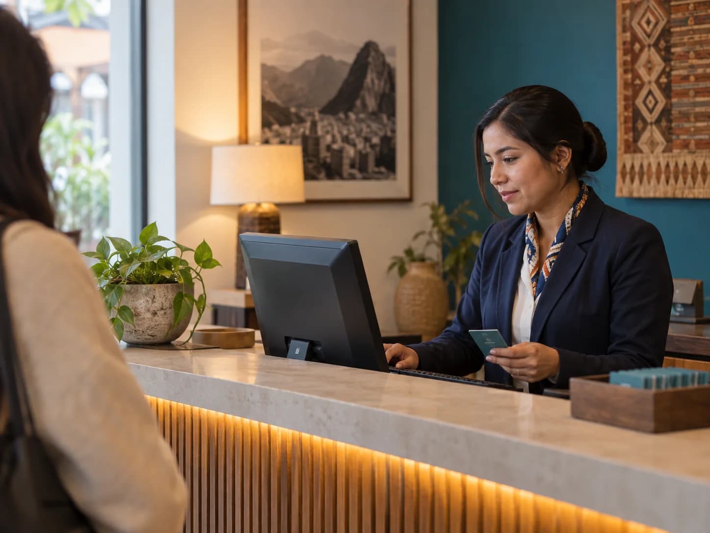 Recepcionista gestionando una reserva desde el mostrador del hotel